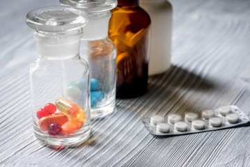 Vitamins and supplements. Pills and pill bottle on grey wooden table background