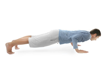 Young man practicing yoga on white background