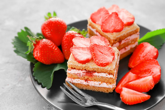 Two pieces of homemade cake with strawberries on plate