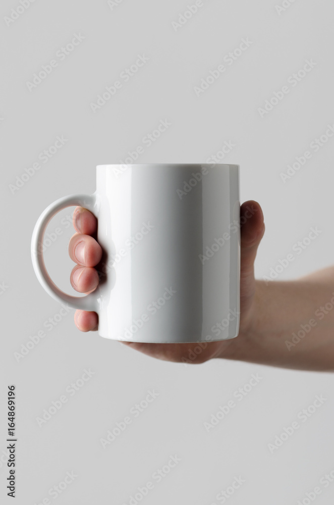 Sticker Mug Mock-Up - Male hands holding a mug on a gray background