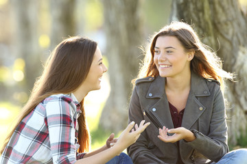 Two friends talking and laughing in a park
