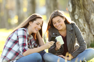 Two friends watching media in their smart phones