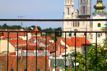 Love locks on Strossmayer Promenade in Zagreb Upper Town. Zagreb Cathedral and St. Mary Church in the background.