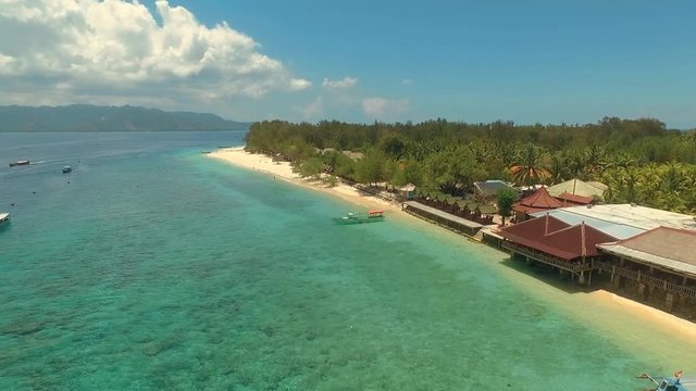 Aerial drone view of Gili Meno tropical Island with blue sky and turquoise water, Lombok mountains in background