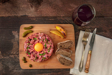 Steak tartare with garnish, red wine, and copyspace