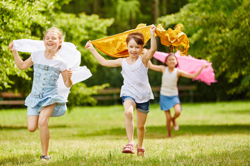 Kinder mit Tüchern im Wind fühlen sich frei