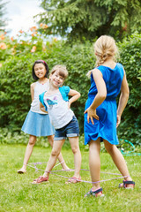 Mädchen spielen ein Hüpfspiel im Garten