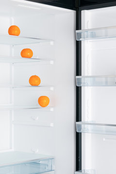 Open fridge with ripe tangerines