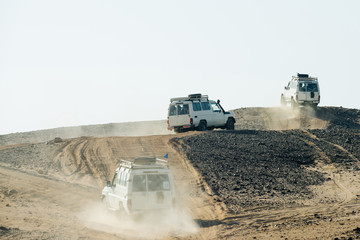 Jeeps bashing through sand dunes in desert
