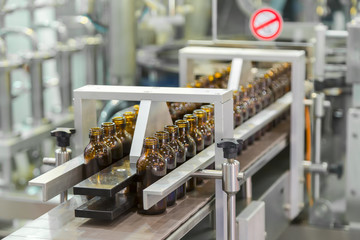 Sterile bottles on the production line conveyor of the pharmaceutical industry. Machine for iquid drugs glassware bottling.