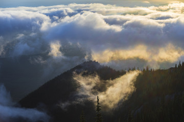 big clouds roll over mountain tops at sunrise