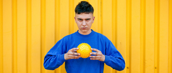 Stylish guy in blue sweater with yellow ball