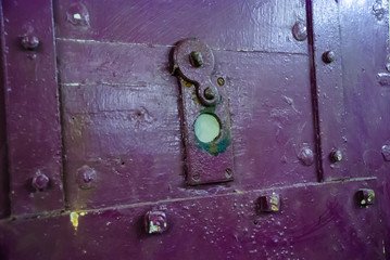 Peephole on a purple prison cell door