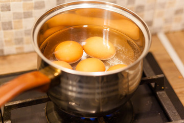 eggs boiling in the water on the gas stove