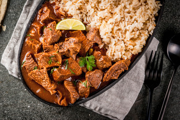 Mexican and American traditional food. Stew beef with tomatoes, spices, pepper - Chile Colorado....
