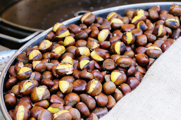 Sweet chestnuts being roasted at a street vendor cart stall.
