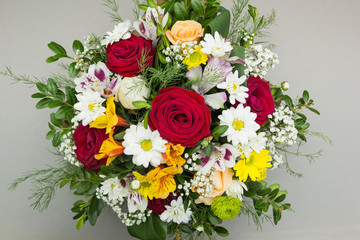 A bouquet of flowers is isolated on a gray background.