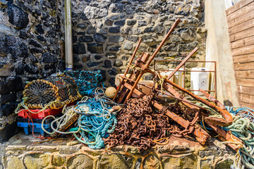 Chains, ropes, lobster cages and other fishing equipment at an old harbour.
