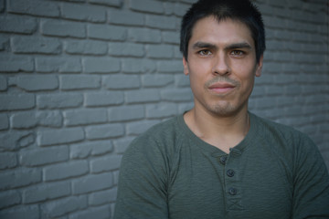 Ethnic Man Smiling in Front of Brick Wall