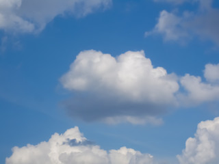 White puffy cumulus clouds in blue sky 