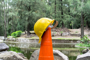 El casco amarillo está sobre el cono de seguridad.