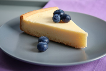 Plate with slice of delicious cheesecake and blueberry, closeup