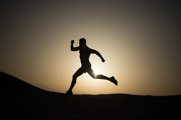 Fototapeta na wymiar running man silhouette at sunset sky