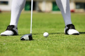 Obraz premium Legs of young man playing golf on course in sunny day