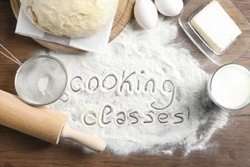 Photo sur Plexiglas Cuisinier Texte écrit sur la farine et les ingrédients, fond en bois. Concept de cours de cuisine