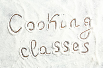 Text written on scattered flour. Cooking classes concept