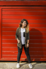 lovely young woman standing in front of red garage door
