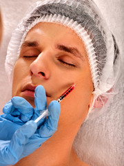 Filler injection for male forehead face. Plastic aesthetic facial surgery in beauty clinic. Man giving anti-aging injections for healthy complexion. Removal of skin defects.