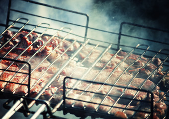 Meat on the grill cooking on the coals, preparation shish kebab or barbecue, shallow depth of field