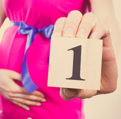 Obraz premium Vintage photo, Hand of woman in pregnant showing number of first month of pregnancy, expecting for baby concept