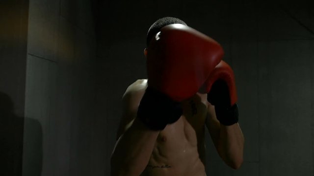 Slow motion of fighter training himself and hitting punches at the sport gym