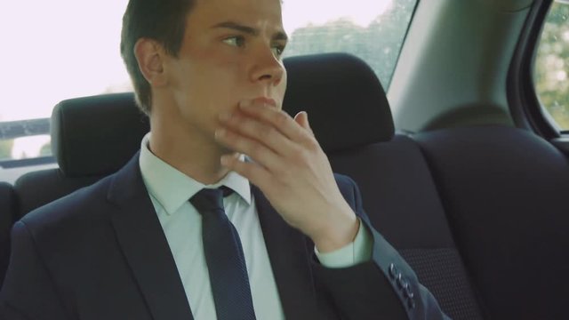 Handsome young businessman going in the car and working with tablet 4K