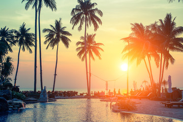 Palm trees on tropical beach during amazing sunset.