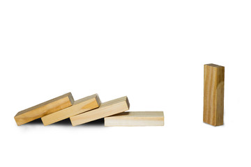 Wooden block standing and outstanding among the collapse of fall in line, business concept able to survive or dominant from destruction. Selective focus on gray background.