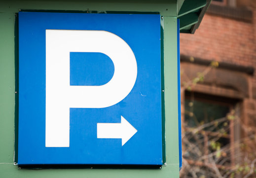blue and white parking sign with arrow pointing right