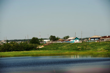 Fototapeta premium Green grass and a river under a blue sky