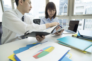 Fototapeta premium Young businessmen are checking the schedule by watching the notebook