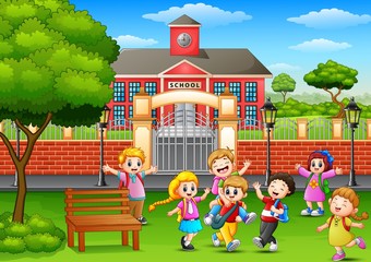 Happy school children playing in front of school building