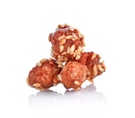 Peanuts sugared on white sesame seeds,close up on a white background.