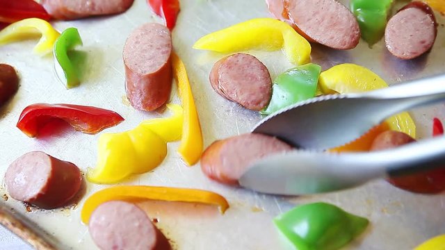 Cooking Polish sausage pieces with colorful bell peppers