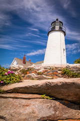 Pemaquid Point Lighthouse atop dramatic rocky coast in Bristol, Maine, on a beautiful summer day