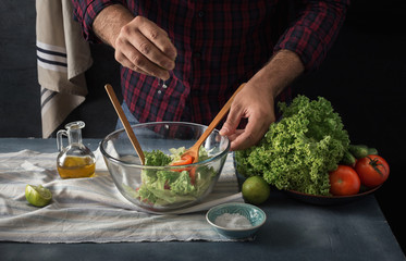 Obraz na płótnie Canvas Man cooking vegetable salad home kitchen hand pouring lemon juice