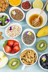 Poster Ingredients for a healthy breakfast, nuts, oatmeal, honey, berries, fruits, blueberry, orange, Edible flowers, Chia seeds, flax seeds, goji berries, almonds walnuts The concept of natural organic food © annaileish