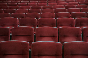 Obraz premium Empty cinema room with red chairs closeup