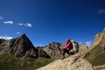 Fototapeta premium successful woman with backpack hiking in mountains