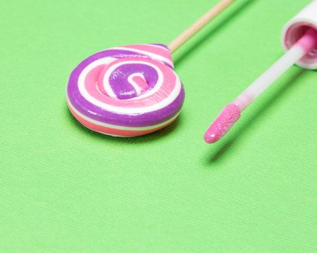 Closeup of pink lip gloss with lollipop